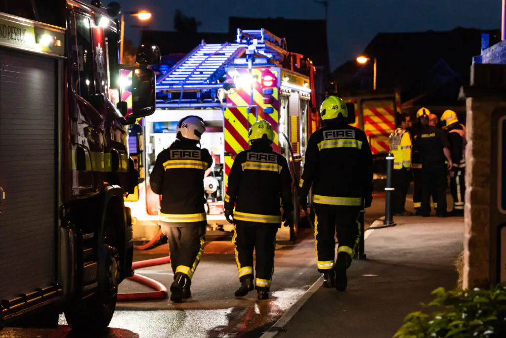 Firefighters wearing black coats