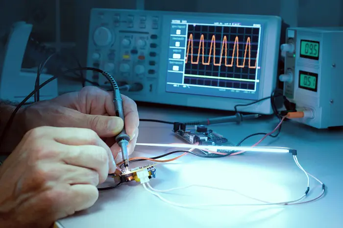 Technician's hands hold small tool