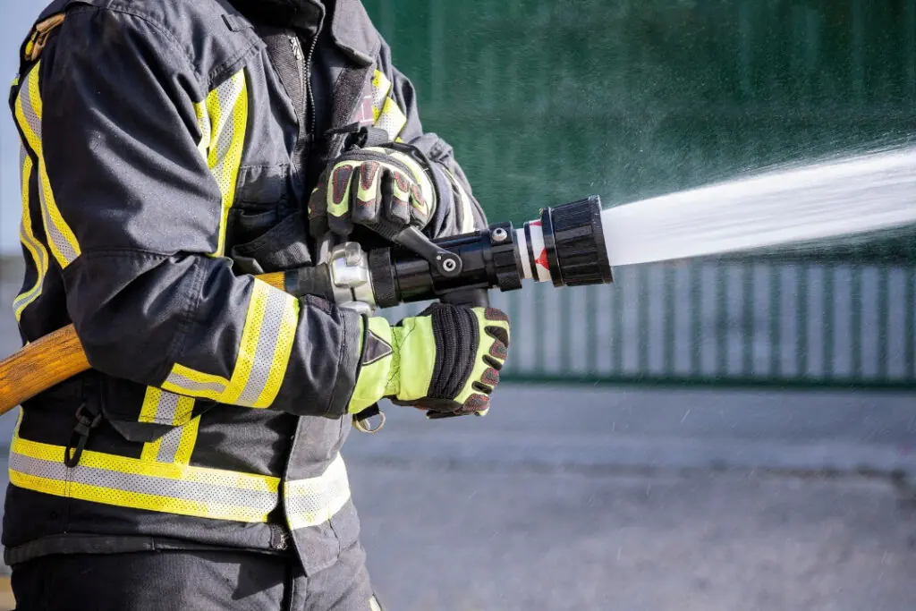 Gloved hands hold fire hose